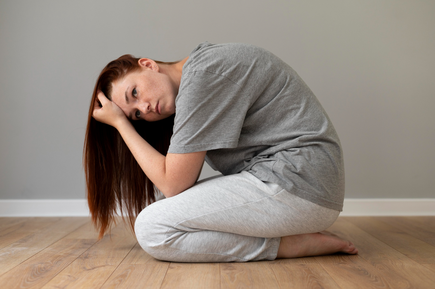 mujer triste agachada en el suelo